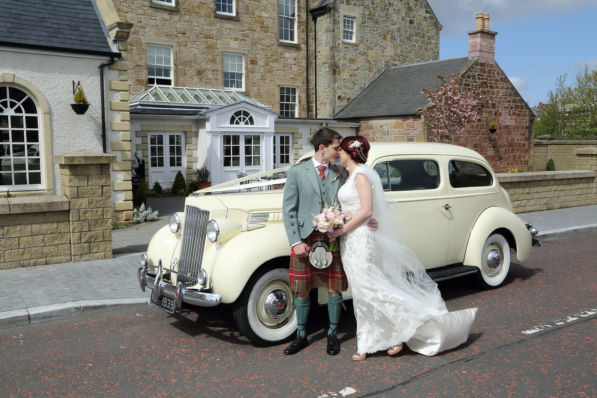 Married couple kissing outside Dumfries Arms Hotel